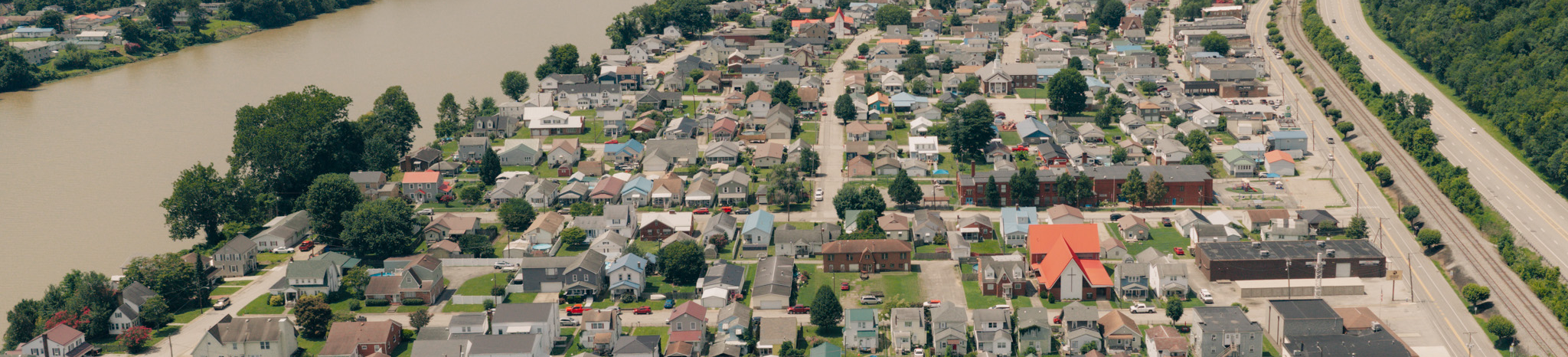 Drone image of Belle, WV showing rows of houses. The kanawha river is on the left side of the screen, then Belle, then route 60.